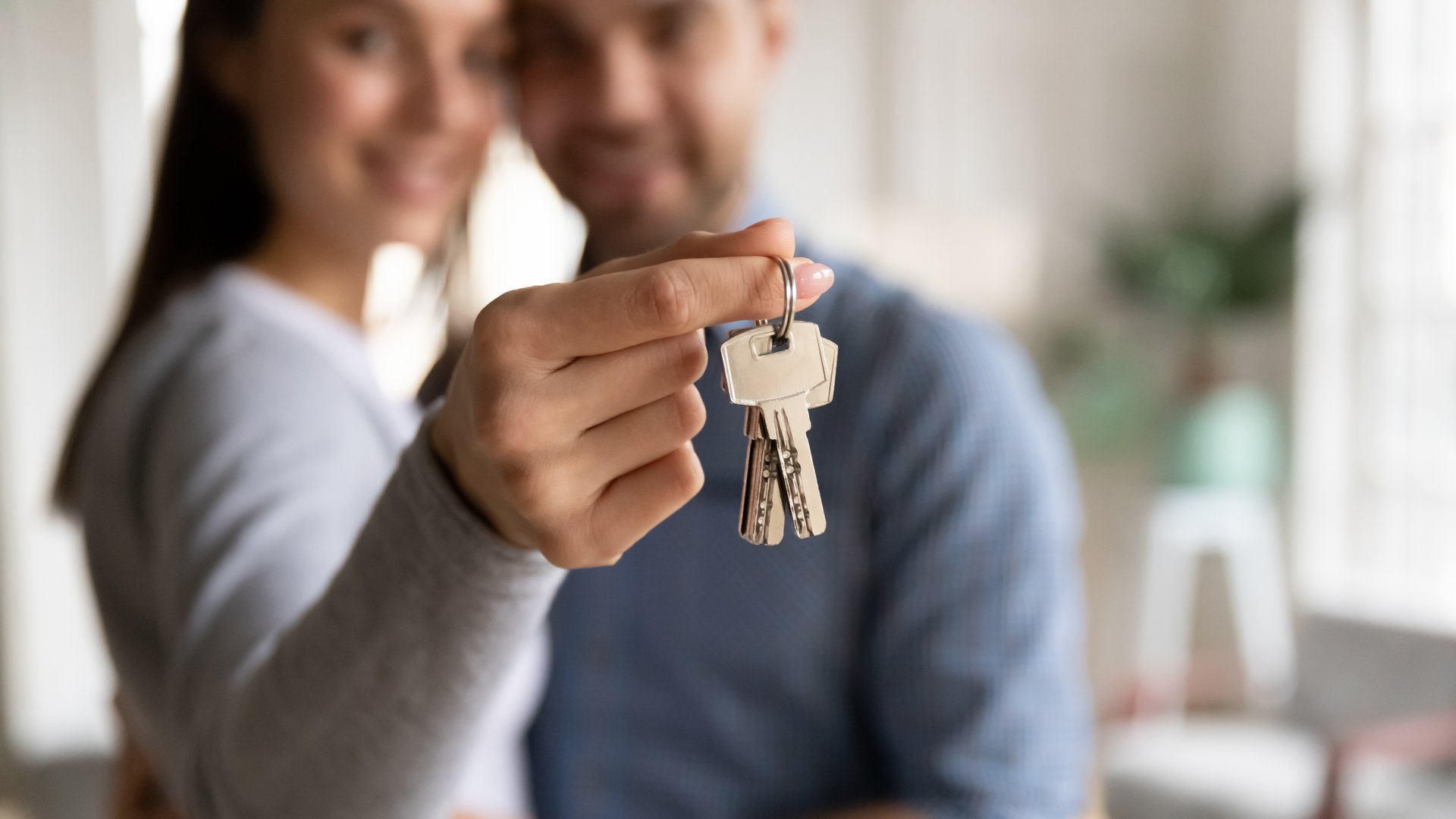 A couple holding the keys to a home.